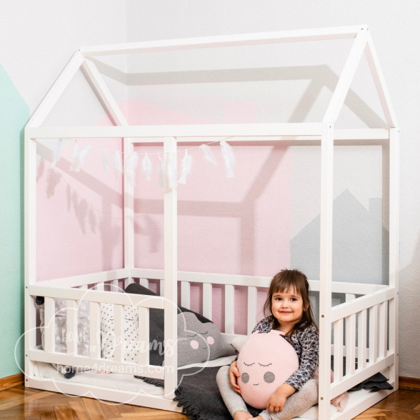 A girl sitting on a toddler house bed