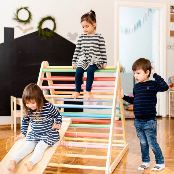 Children sliding down a wooden climbing frame 