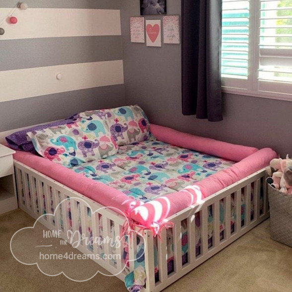 Wood toddler bed with a mattress and bedding