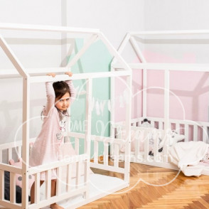 Two toddler floor beds with rails placed next to each other, with children playing in them