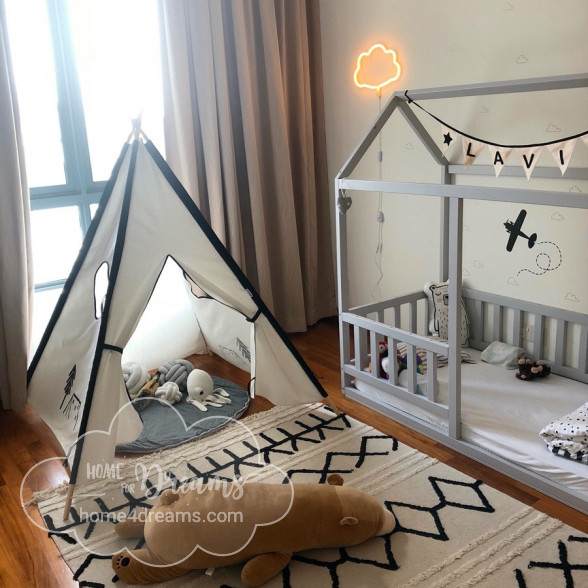 A children’s teepee next to a toddler bed