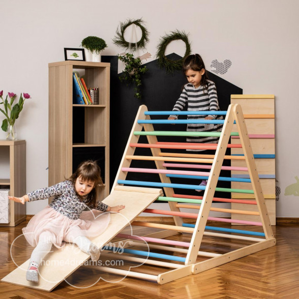 A girl sliding down a triangle climber toy with a slide board