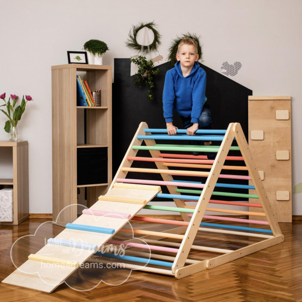 A child standing on a wooden pikler triangle climber with rainbow-colored rungs
